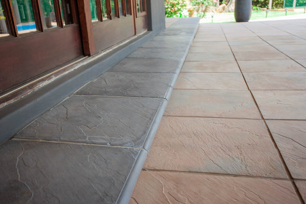 Rough textured pavers with matching coping on a traditional patio