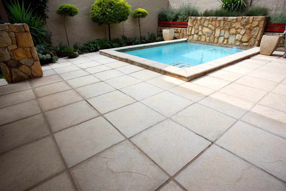Small square pool with non-slip paving in a light blended colour
