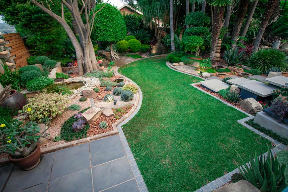 Garden with stone features and lawn defined with garden edging.