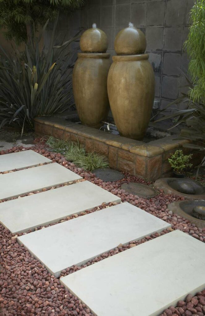 Ibanzi Paver in Grey with brown pebbles in between creating a stepping stone walkway