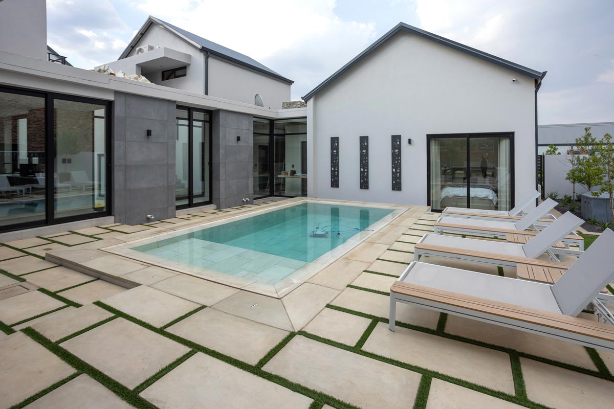 Modern pool area featuring large format concrete pavers Ibanzi Paver